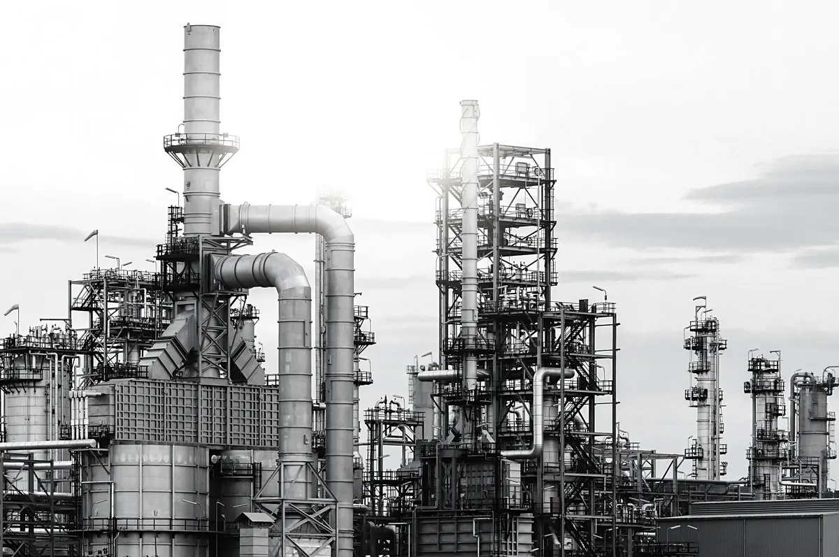 Refinery towers and pipework against a pale sky
